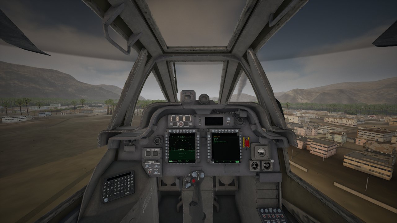 From the Apache pilot's own rear seat over Khasab in the late sun: the front canopy frames, the instrument panel with its two live displays, the town below.