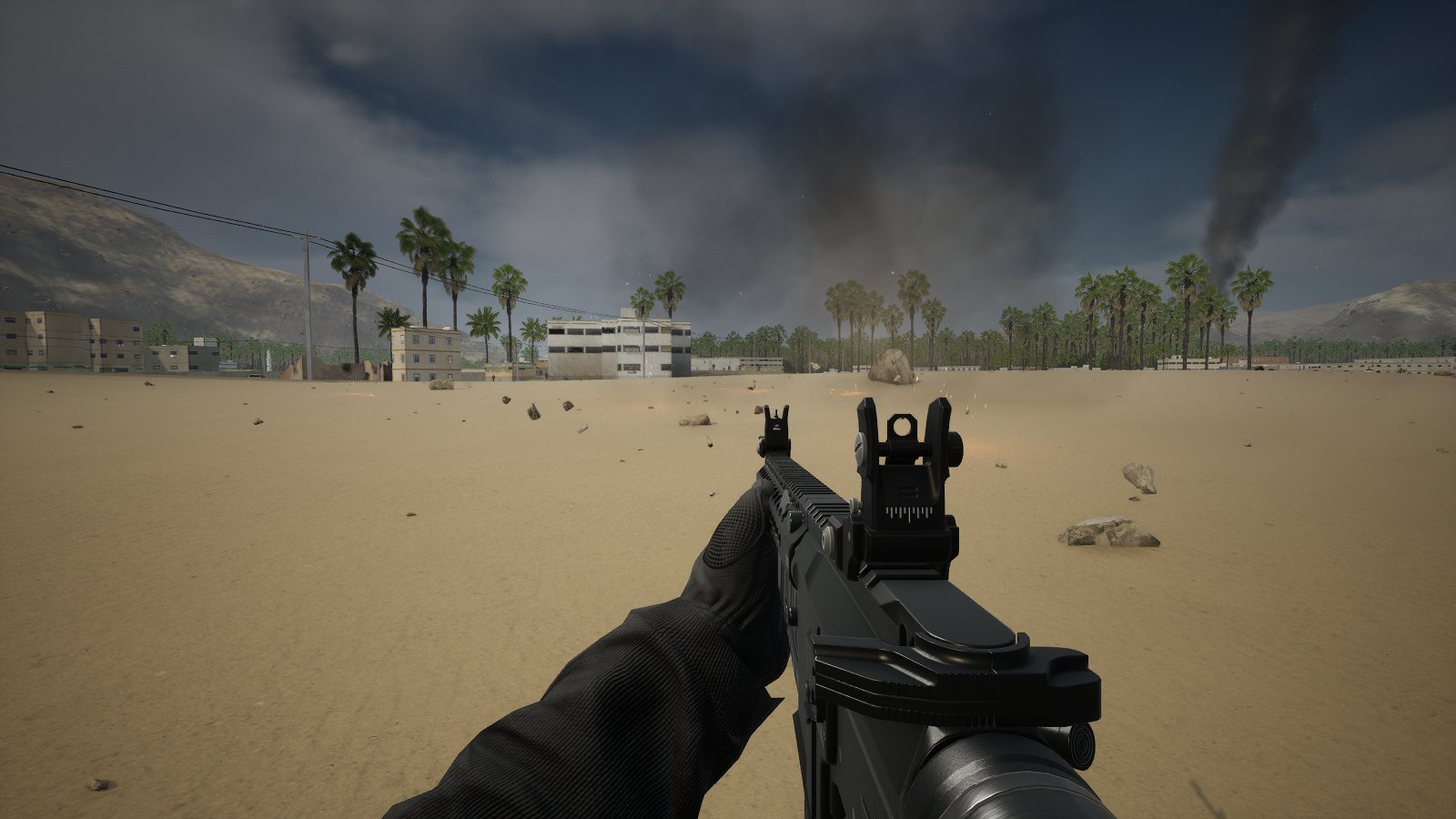 The same spot seconds later: the wall gone, its broken blocks scattered across the sand, smoke drifting off.